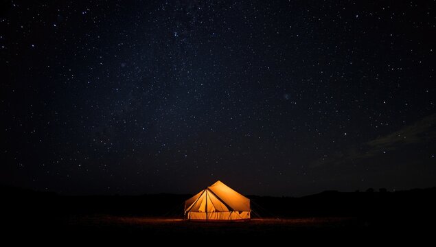 Radiant tent aglow under a deep dark sky full of stars