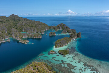Obraz premium Turquoise lagoons between limestone islands viewed from above in Piaynemo Raja Ampat Indonesia