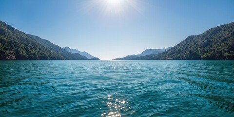 Vibrant sunshine shining on calm sea with forest covered hills © AkuAku