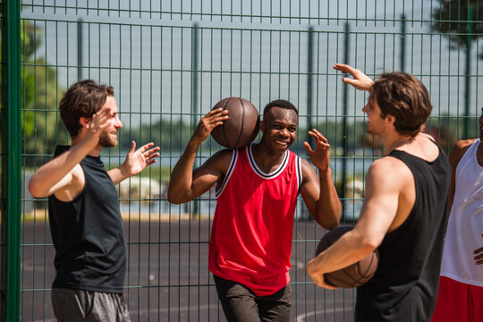 Exciting summer basketball game with multicultural friends outdoors