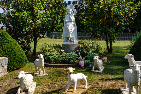 France. Hautes-Pyr&eacute;n&eacute;es. Lourdes. A statue of Saint Bernadette Soubirous, surrounded by figurines of sheep that recall her childhood as a shepherdess