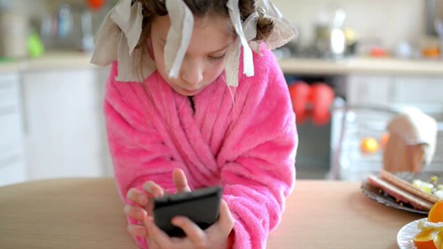 Little beautiful girl plays on her mobile phone