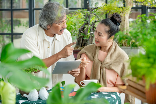 Happy mature adults exploring online information together in a relaxing green environment highlighting technology learning financial planning and active retirement.

