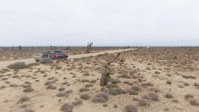 Suv drives through the desert terrain of Baja California Mexico while towing a teardrop camper trailer on an overland journey.