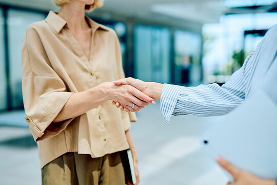 Two professional businesswomen shaking hands establishing a new agreement or partnership, collaborating on a successful deal