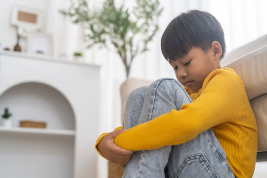 Bullying awareness, sad asian boy sitting alone hugging knees, child mental health, psychological trauma, emotional distress, depression symptom, social isolation, school violence and silent victim