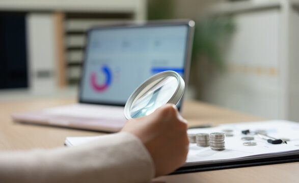 Financial analyst examining business reports with magnifying glass, highlight financial audit investment analysis, budget planning, account data verification business intelligence and risk assessment.