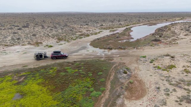 A journey through the Baja California Mexico desert with a teardrop camper trailer being pulled by an SUV on dirt roads and sandy trails