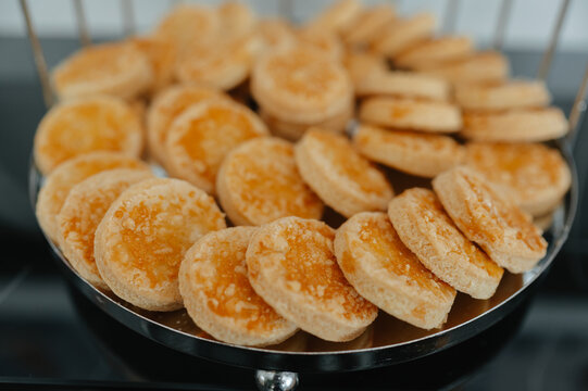 Close view of round golden cakes arranged in metal tray, highlighting browned tops and soft texture today
