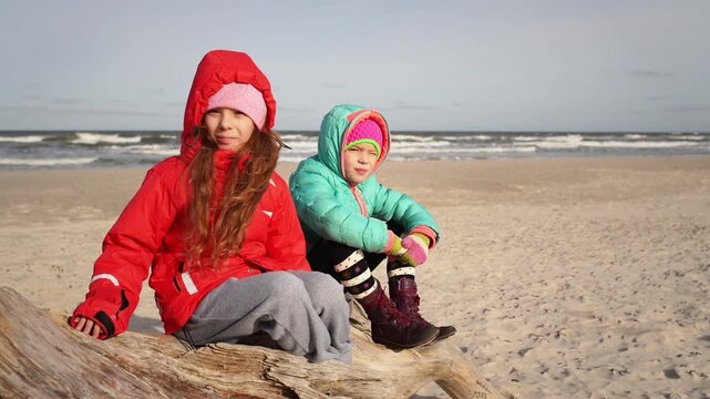 Little beautiful girls sits about sea