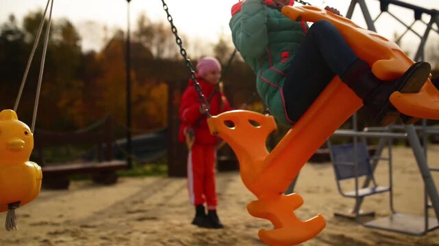 Two beautiful little girls on swing