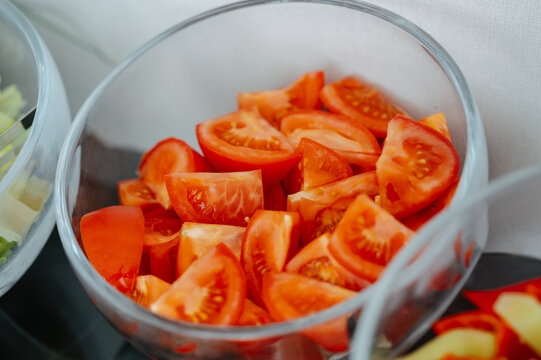 Bright red tomato chunks fill clear bowls, showing fresh ingredients staged for cooking and serving today