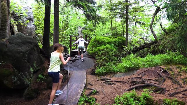 Two little beautiful girls walk on Szczeliniec Wielki - highest peak in Table Mountains National Park, Poland. It belongs to Crown of Polish Mountains with panoramic views of Sudetes.