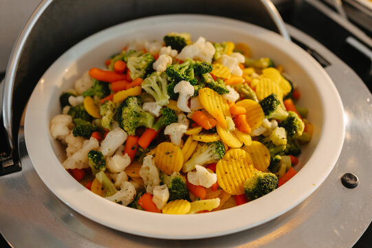 Mixed vegetables cooked and served with broccoli cauliflower carrots and potatoes in bright natural light