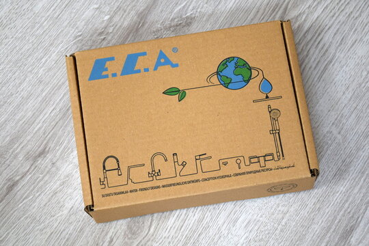A closed cardboard product box of the Turkish plumbing brand E.C.A. with a blue logo, eco-friendly earth illustration, and line icons of faucets. 