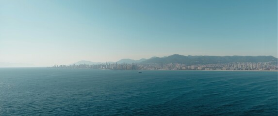 Fototapeta premium Coastal city skyline viewed from the ocean under clear sky