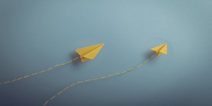 Yellow paper airplanes flying against a blue background