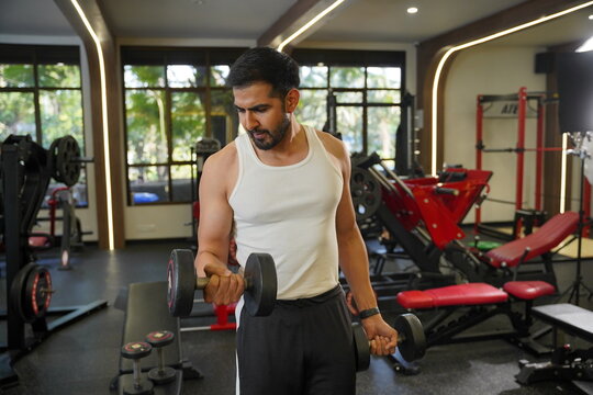
Maharashtra, Sion, India- 22nd March 2026- Young Indian guy doing workout with dumbbells in gym.