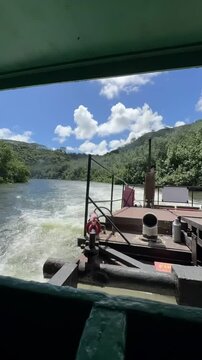 21 October 2024, USA, Hawaii, The Garden Isle, Kauaʻi, Kapaa, Wailua River - timelapse fern grotto tourist boat tour overlooking riverbank