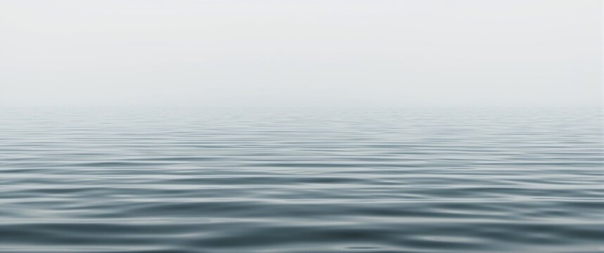 Calm water surface with gentle ripples under a cloudy sky