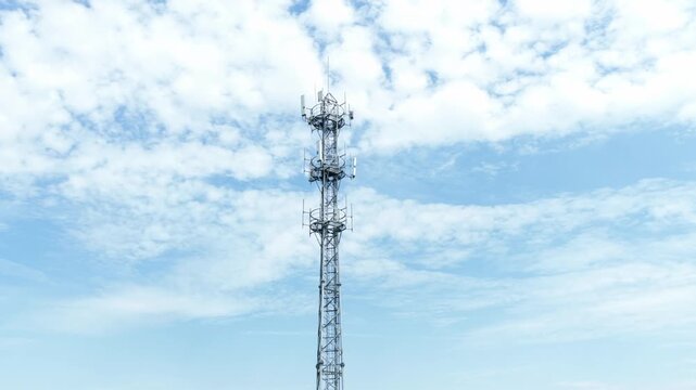Communication signal tower under blue sky and white clouds