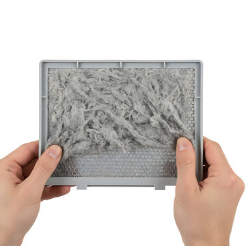 Hands holding a dirty air filter filled with dust and debris  