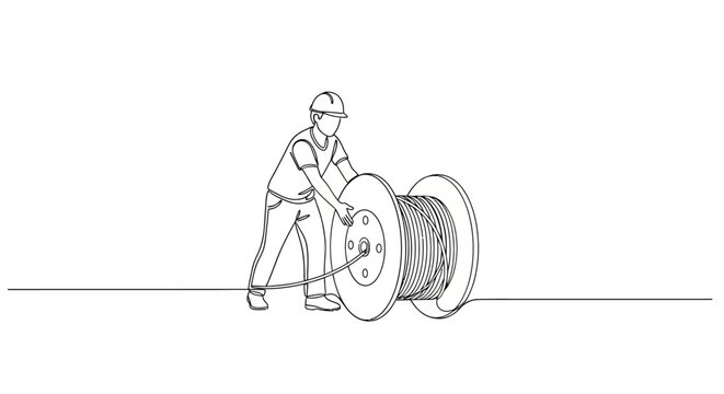 Person pushing large spool of cable on ground.