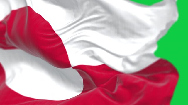 The flag of Greenland waving in the wind isolated on green background