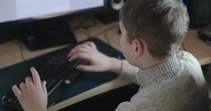 Kid Boy Use Desktop Computer for Study Typing and Reading. 4K 10-bit