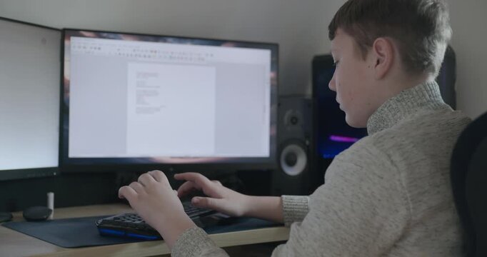 Kid Boy Use Desktop Computer for Study Typing and Reading. 4K 10-bit