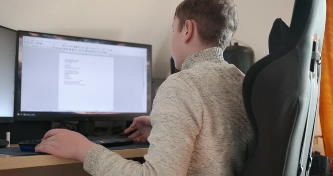 Kid Boy Use Desktop Computer for Study Typing and Reading. 4K 10-bit