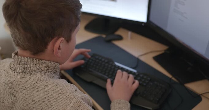 Kid Boy Use Desktop Computer for Study Typing and Reading. 4K 10-bit