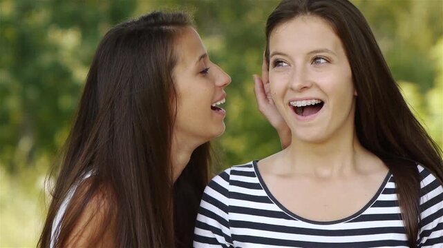 two woman whispering