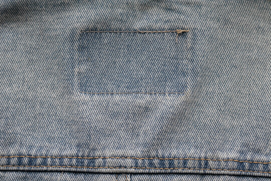 Denim fabric texture with rectangular stitched patch