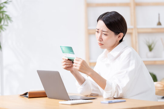 通帳を見て考える女性