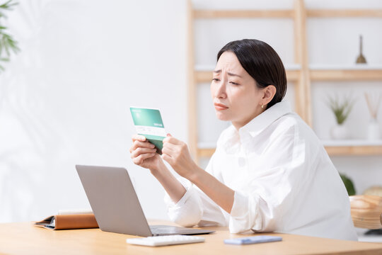 通帳を見て考える女性