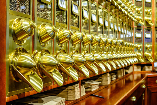 Various brass dispensers for condiments at a food service location in the city, ready for use during busy lunch hours, inviting customers to choose their toppings