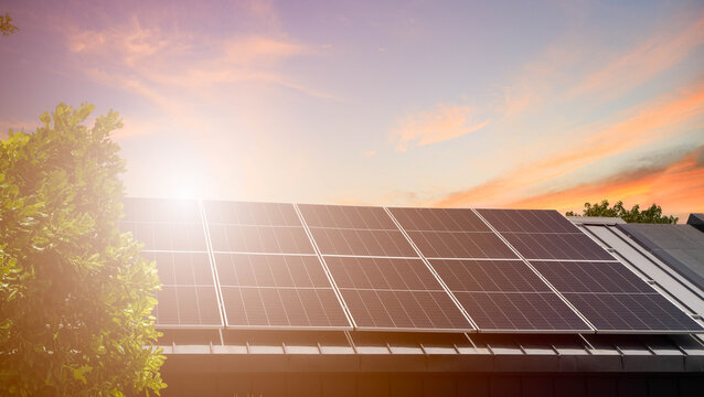 Clean green energy concept with solar cell panels installed on building roof at sunset.Solar panels on the roof of a house with beautiful sunset sky background.