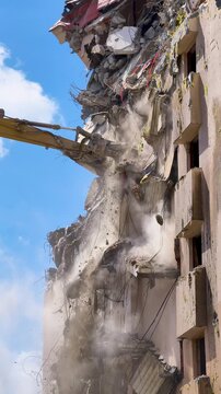 Building demolition takes place with heavy machinery during daylight hours