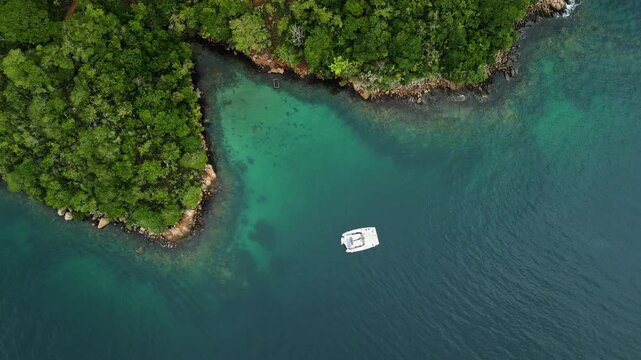 Aerial view of the lush green coastline with boat anchored in the shallows