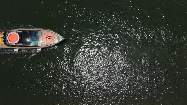 Top down aerial view of a luxury yacht cruising on dark water