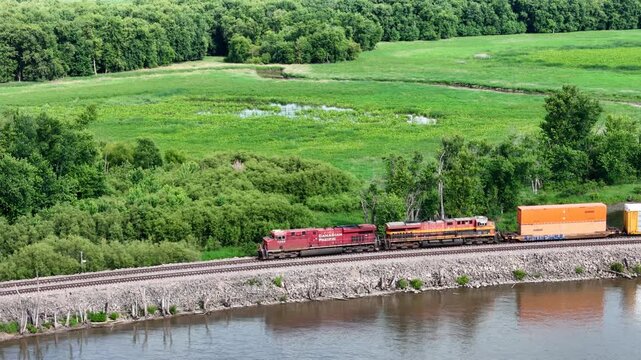 freight train passing along the back waters of the Mississippi river in summer landscape
