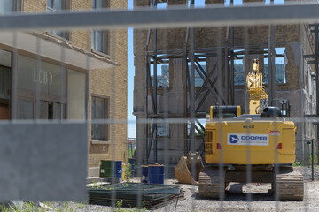 Obraz premium heavy construction equipment seen behind mesh barrier fence, at the former LCBO headquarters (55 Lake Shore Blvd E), Toronto