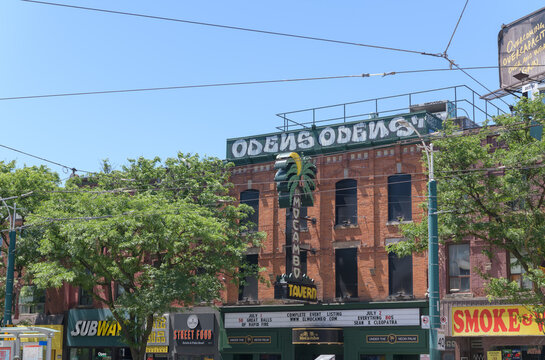 wide distant view of building facades and signs including El Mocambo a live music venue located at 464 Spadina Av, Toronto