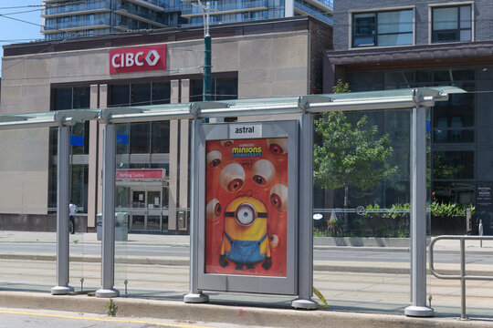 transit shelter OOH advertising featuring Minions & Monsters animation and defocused view of CIBC bank branch at 268 College St, Toronto