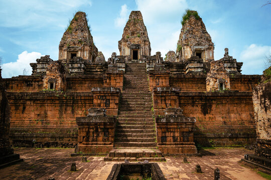View of the ancient Pre Rup temple with its tiered stone structure, central towers, and steep stairs under a blue sky in Krong Siem Reap, Siem Reap Province, Cambodia.