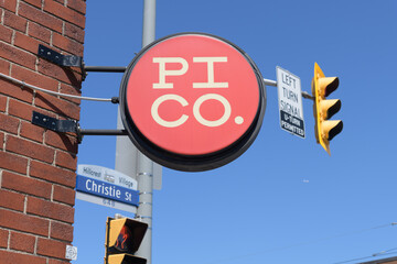 Obraz premium skyward view of wall-mounted round projecting sign outside Pi Co pizza southwest corner of Christie St and 687 St Clair Av W, Toronto