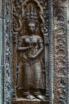View of an intricate stone Apsara carving featuring traditional Khmer attire and an ornate headdress on a temple wall in Krong Siem Reap, Siem Reap Province, Cambodia.