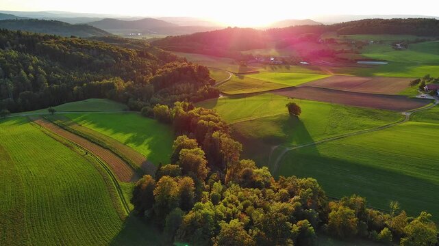 Breathtaking Sunset Over Verdant Countryside with Farms and Forests