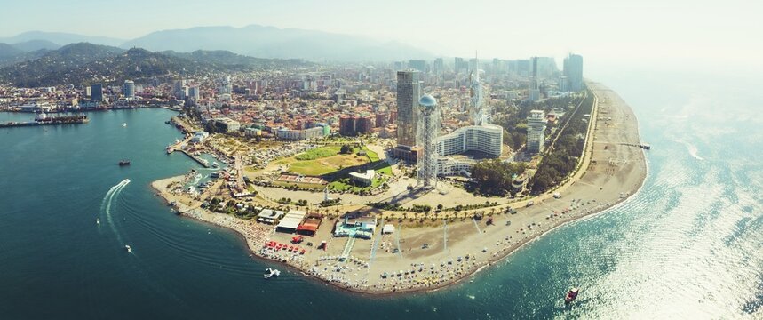 Aerial panoramic view Batumi cityscape with beach and promenade attractions, tourist in sunny summer day. Popular Georgia black sea coastline city holiday destination
